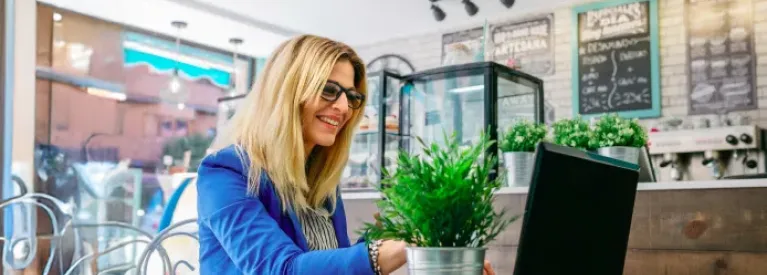 Przedsiębiorczyni pracująca przy laptopie w kawiarni